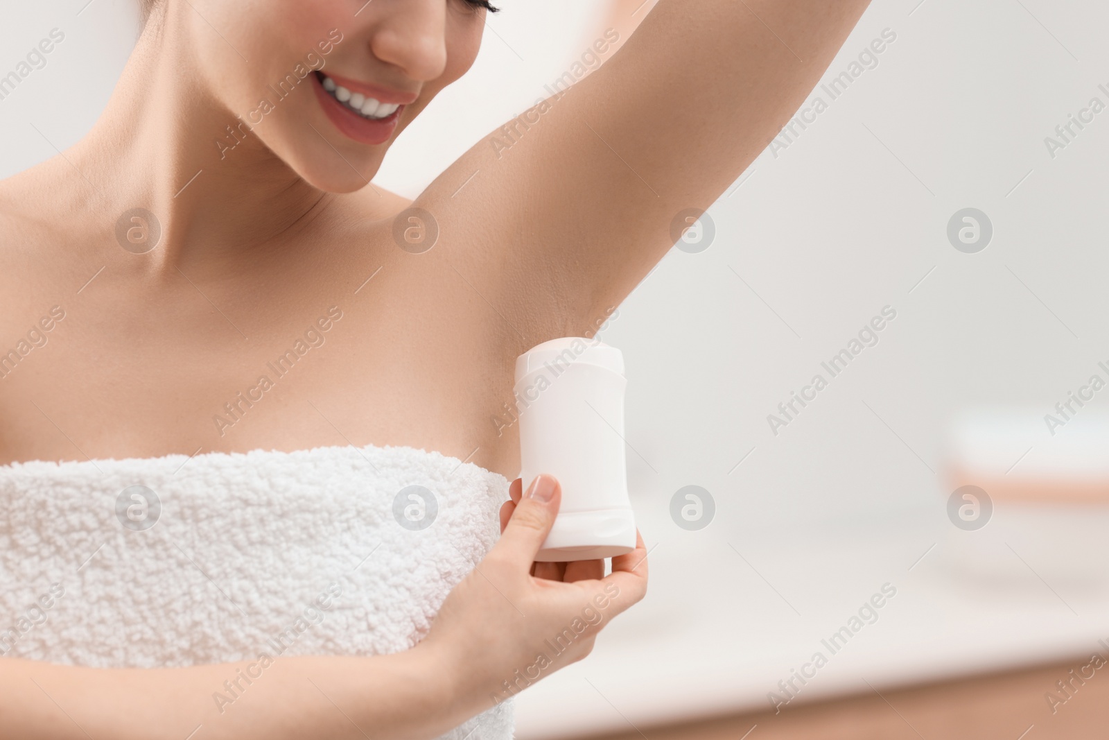 Photo of Woman applying deodorant in bathroom, closeup. Space for text