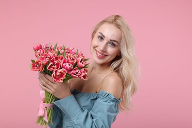 Photo of Happy young woman with beautiful bouquet on dusty pink background