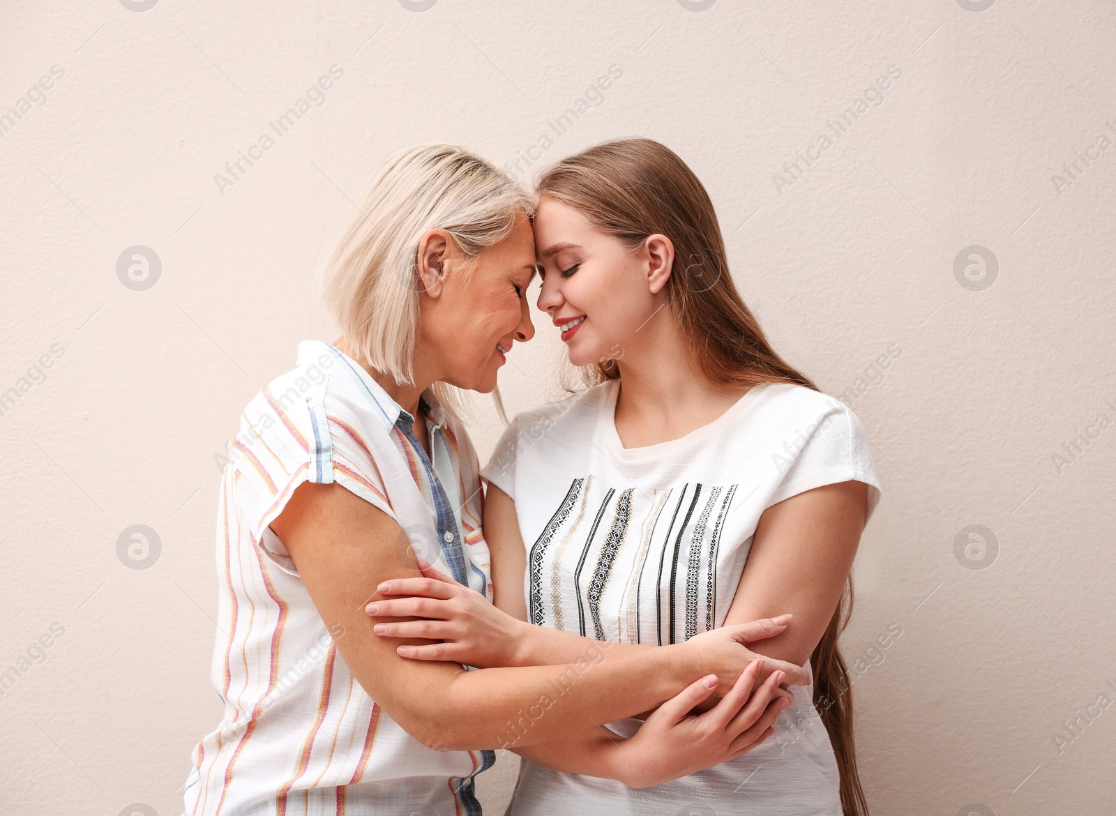 Photo of Mother and her adult daughter on beige background
