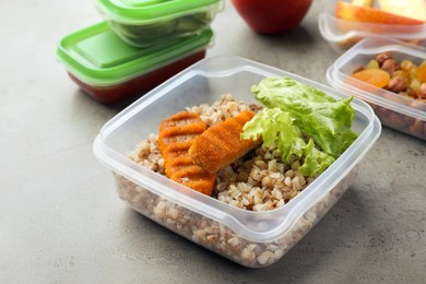 Photo of Set of plastic containers with fresh food on light grey table