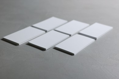 Photo of Blank business cards on light grey textured table, closeup. Mockup for design