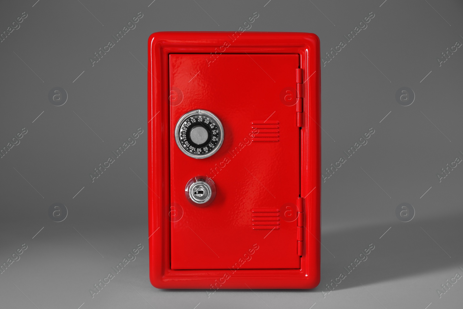Photo of Closed red steel safe on light grey background