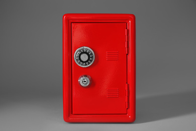 Photo of Closed red steel safe on light grey background