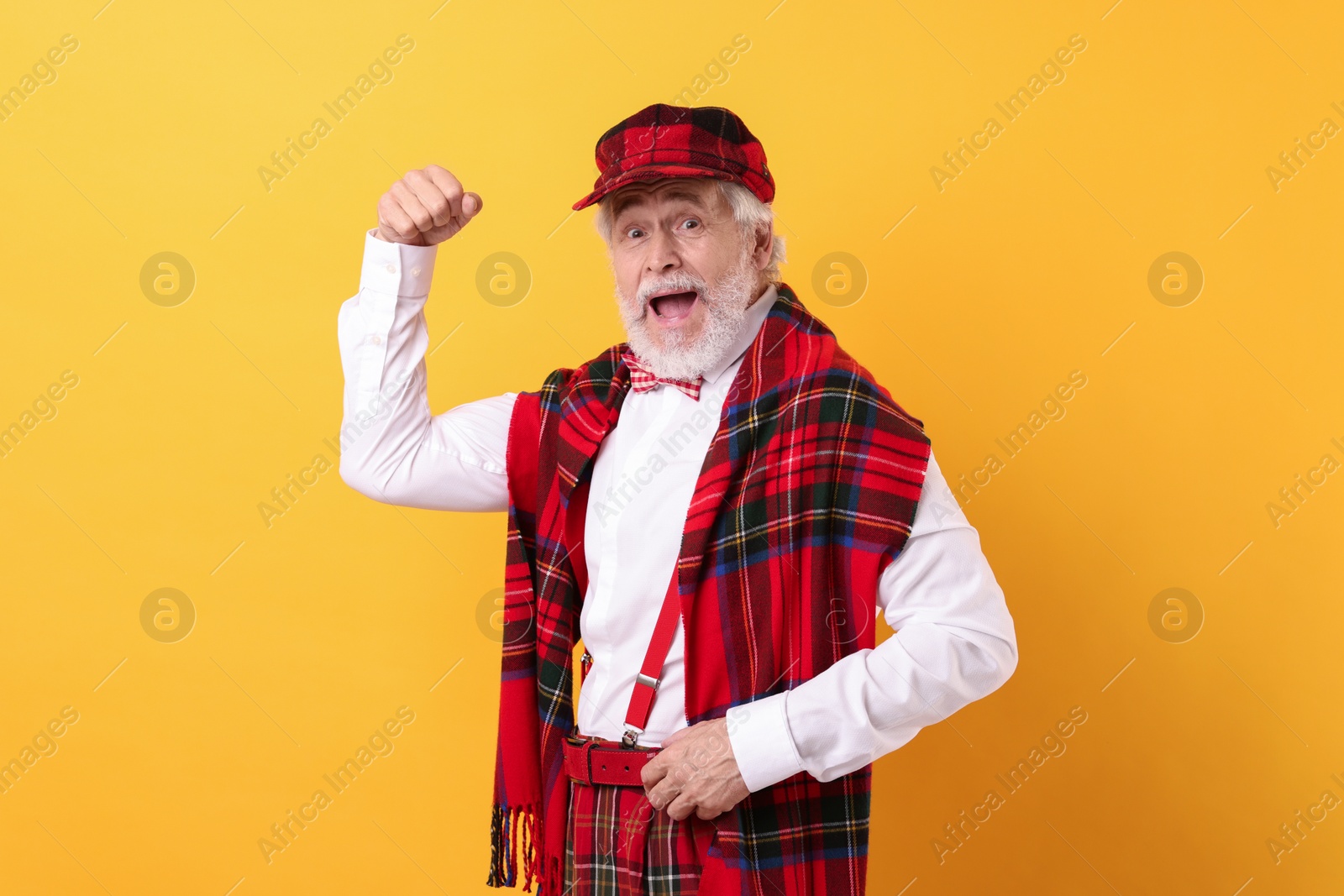 Photo of Portrait of grandpa with stylish hat and bowtie on yellow background