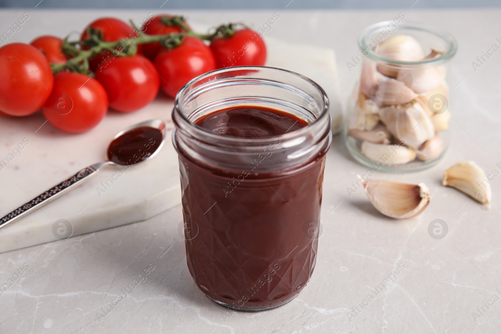 Photo of Composition with jar of barbecue sauce on light table