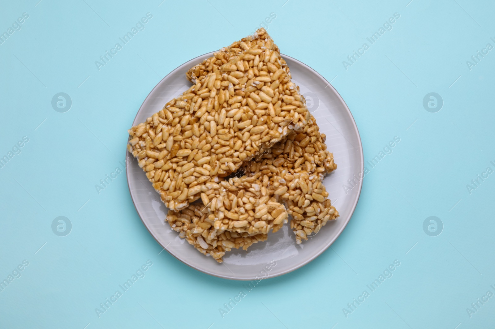 Photo of Puffed rice bars (kozinaki) on light blue background, top view