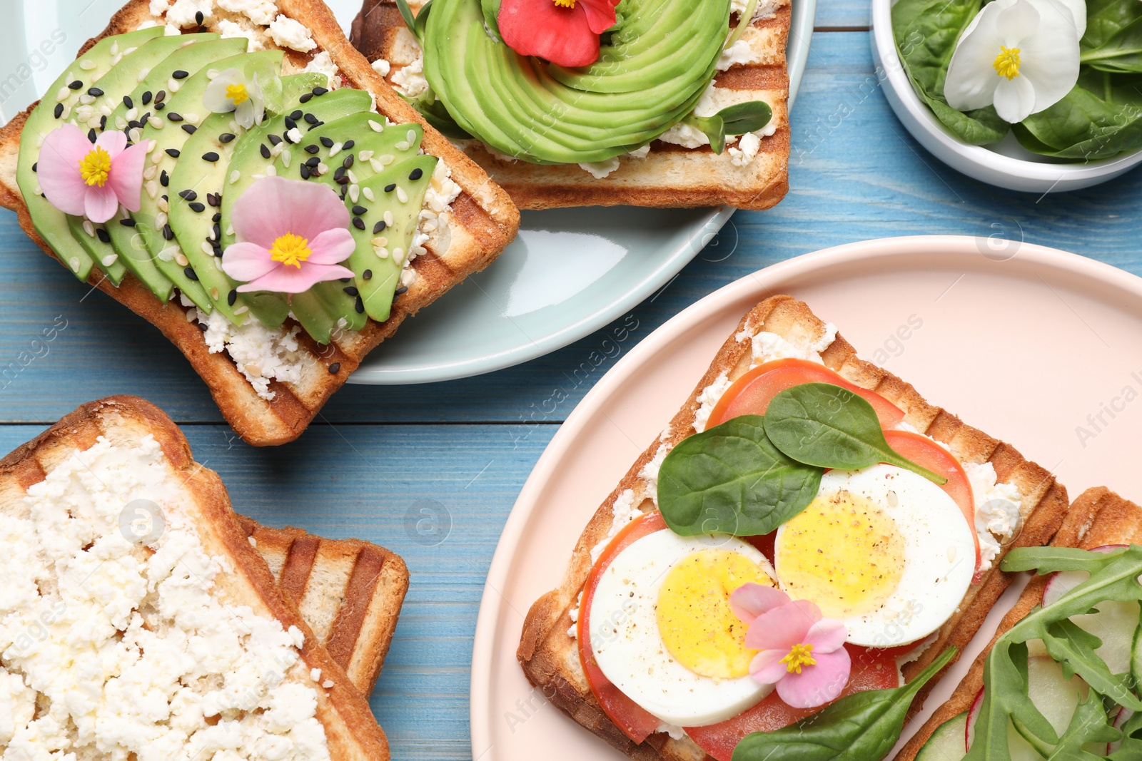 Photo of Different delicious sandwiches on light blue wooden table, flat lay