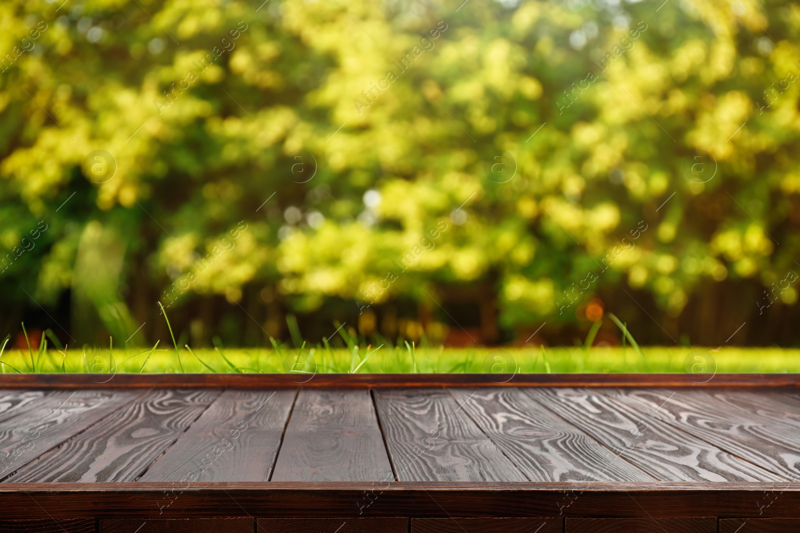 Image of Empty wooden surface against blurred green background. Space for design