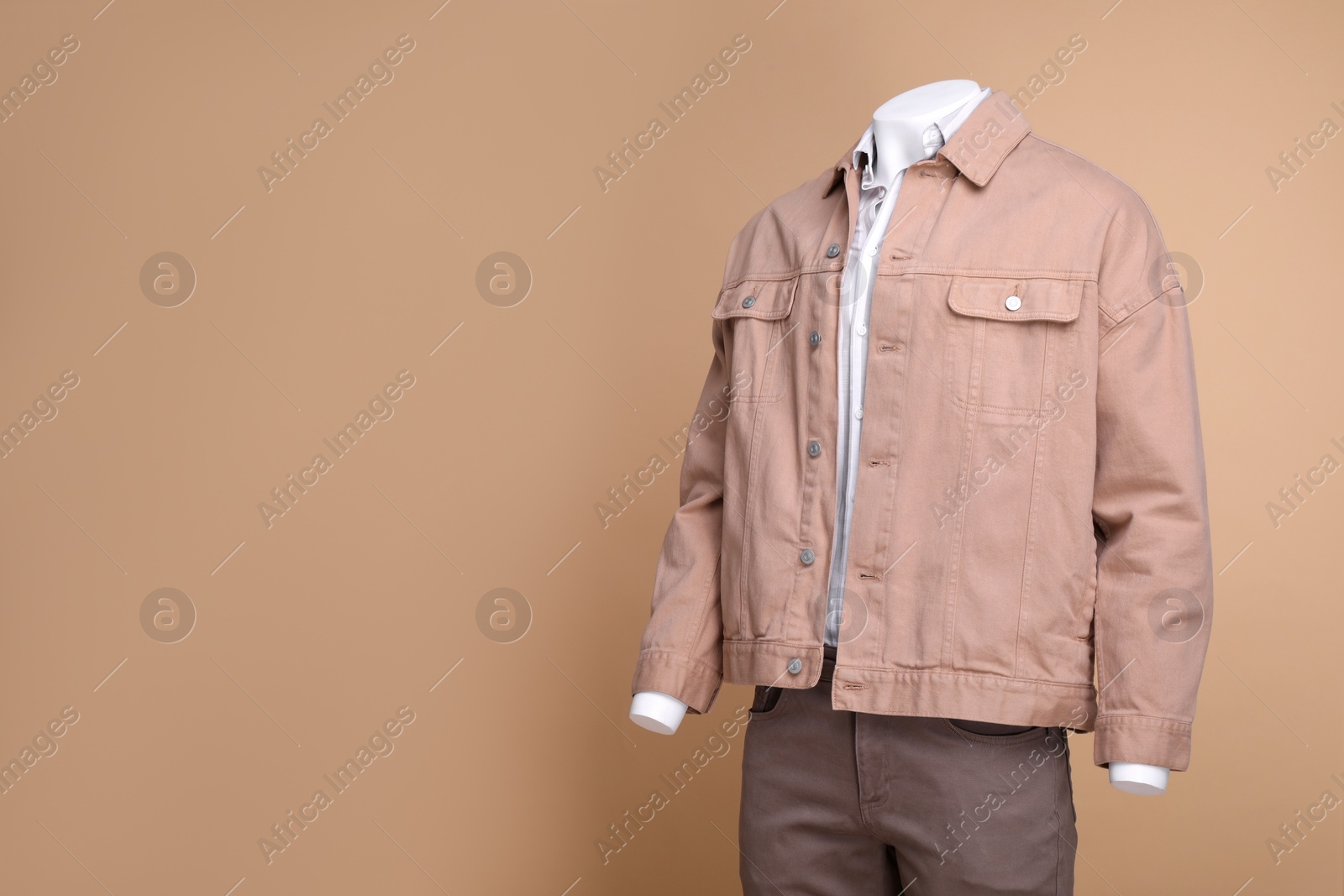 Photo of Male mannequin dressed in white shirt, jacket and pants on beige background, space for text