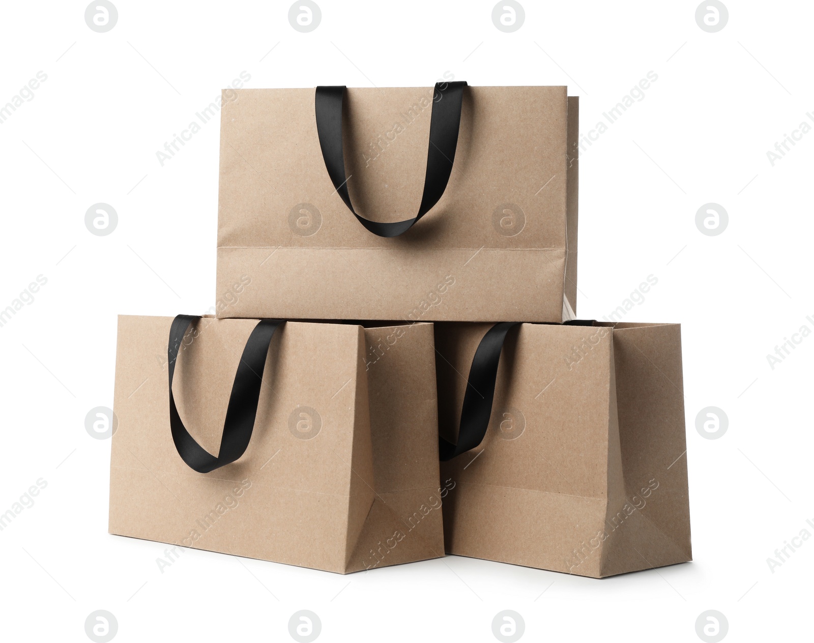 Photo of Paper shopping bags with ribbon handles on white background. Mockup for design