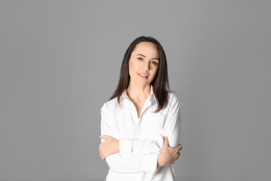 Portrait of beautiful mature woman on grey background