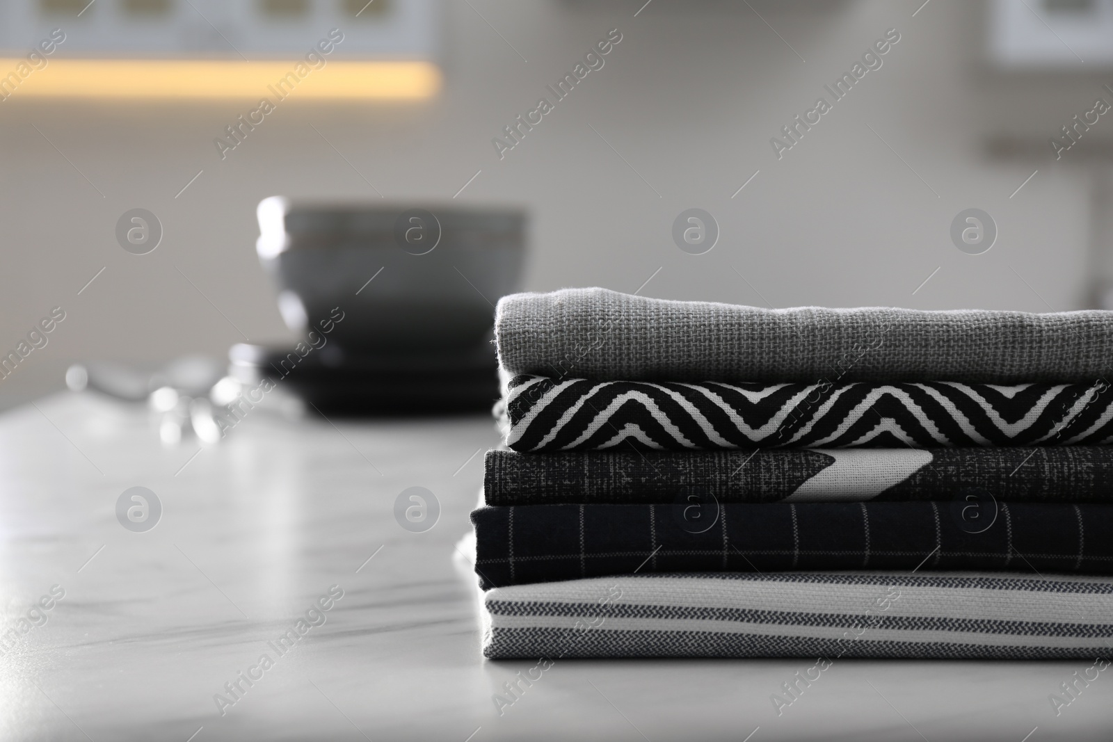 Photo of Stack of soft kitchen towels on white table indoors, space for text