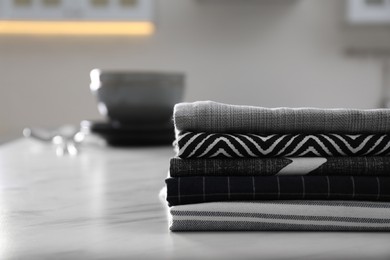 Photo of Stack of soft kitchen towels on white table indoors, space for text
