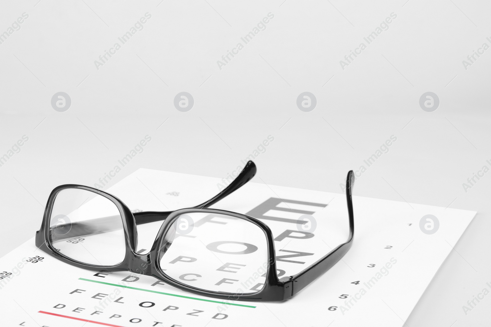 Photo of Glasses and vision test chart isolated on white