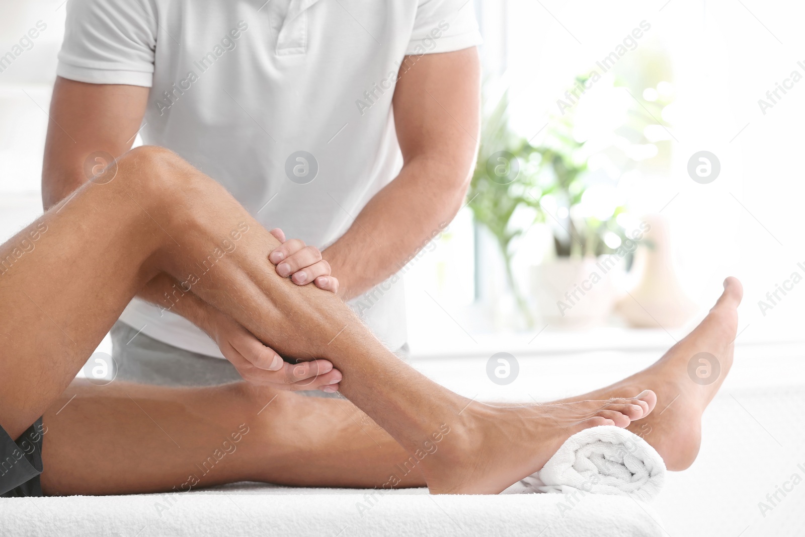 Photo of Young man receiving massage in salon, closeup