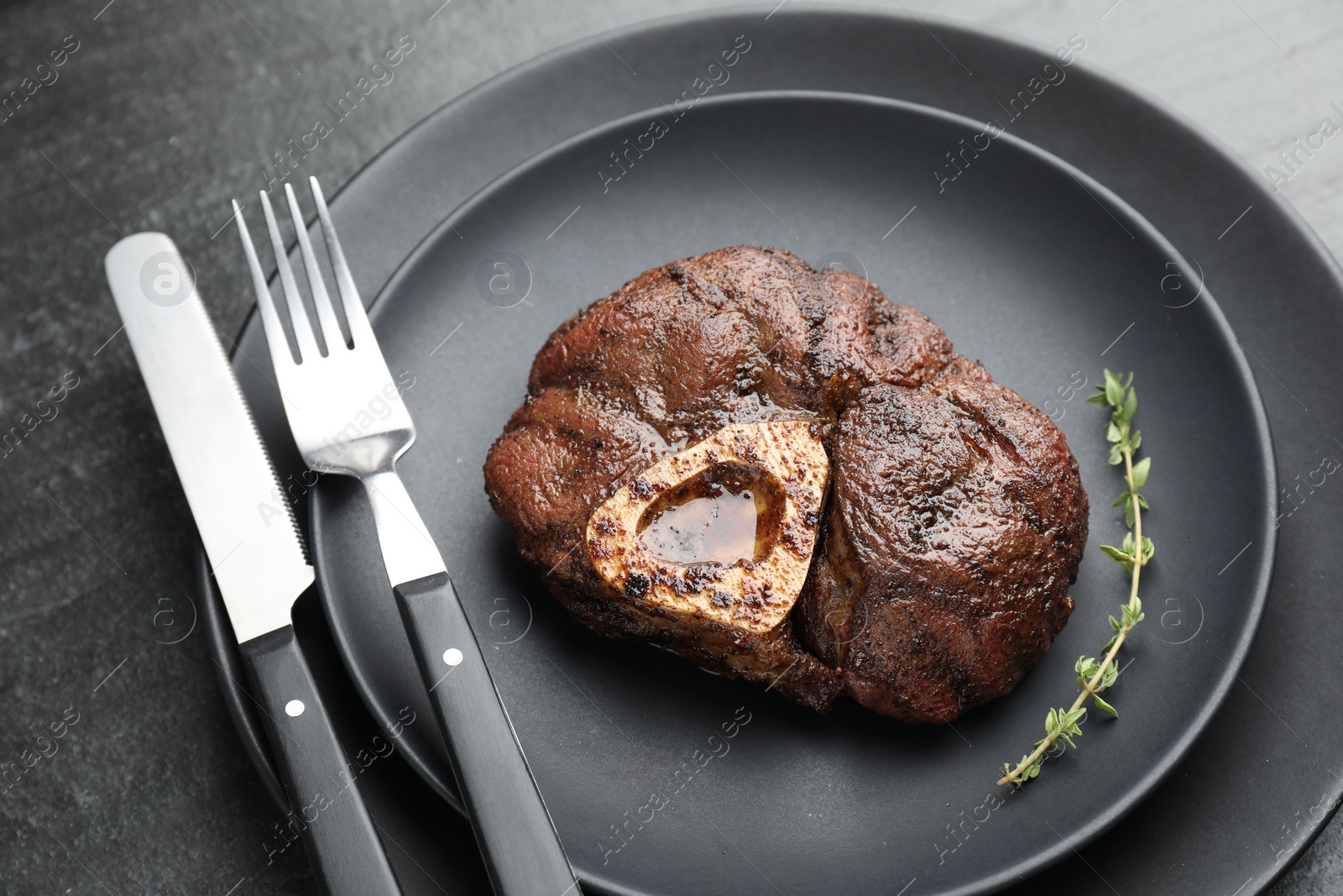 Photo of Tasty grilled beef meat served on black table, closeup