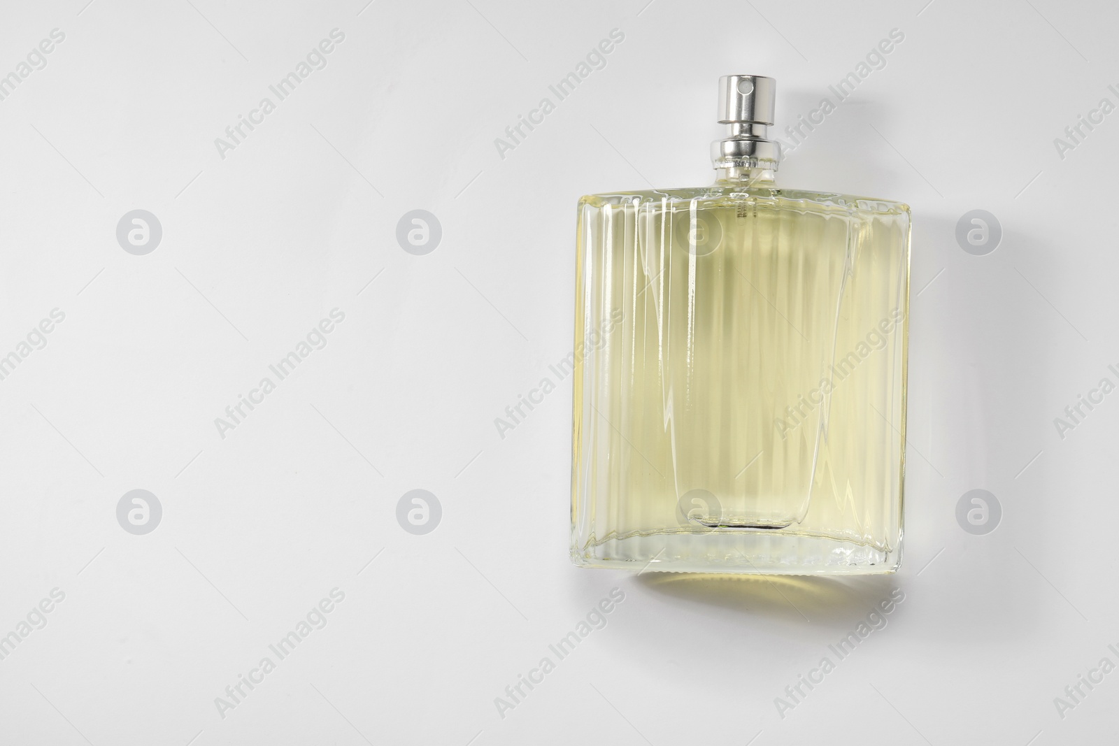 Photo of Luxury men`s perfume in bottle on white background, top view. Space for text