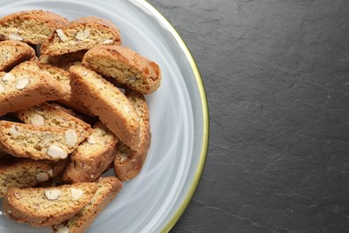 Photo of Traditional Italian almond biscuits (Cantucci) on grey table, top view. Space for text