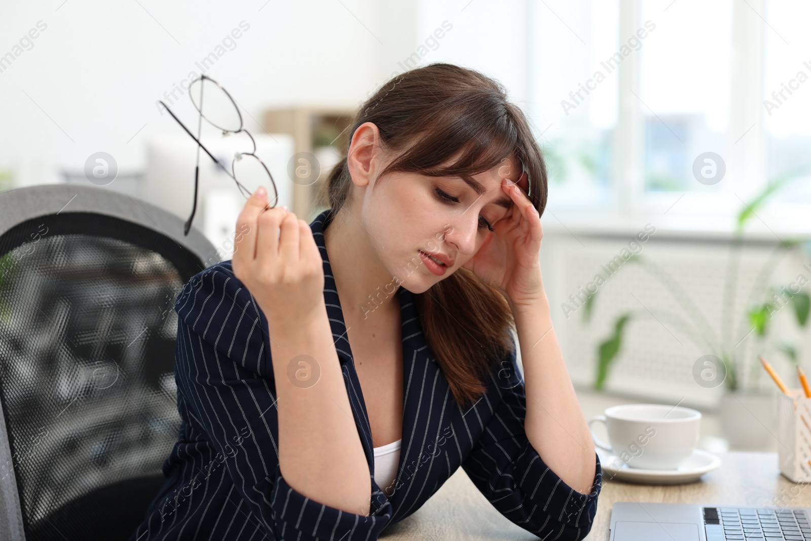 Photo of Overwhelmed woman with glasses suffering in office