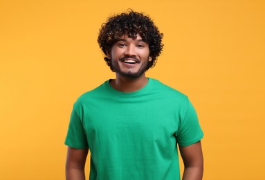 Photo of Handsome young smiling man on yellow background