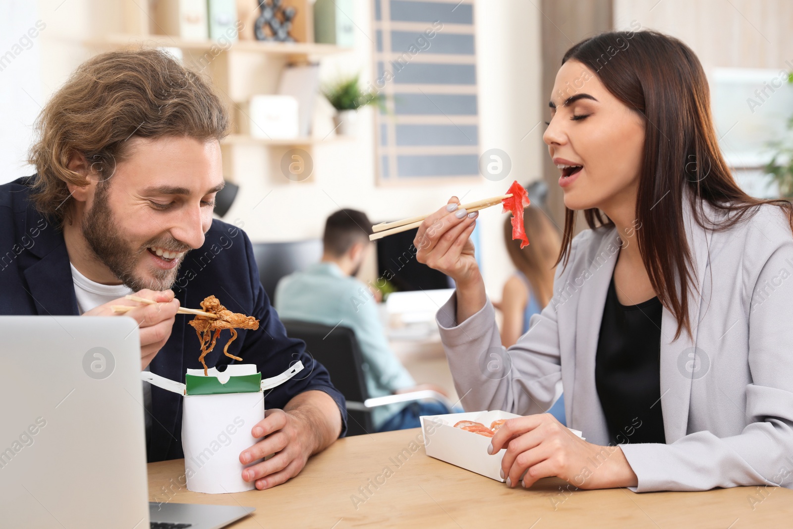 Photo of Office employees having lunch at workplace. Food delivery