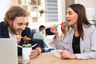 Photo of Office employees having lunch at workplace. Food delivery