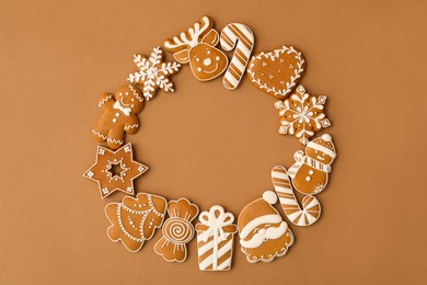 Photo of Frame made with different Christmas gingerbread cookies on brown background, flat lay. Space for text