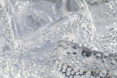 Photo of Soda water with ice as background, closeup