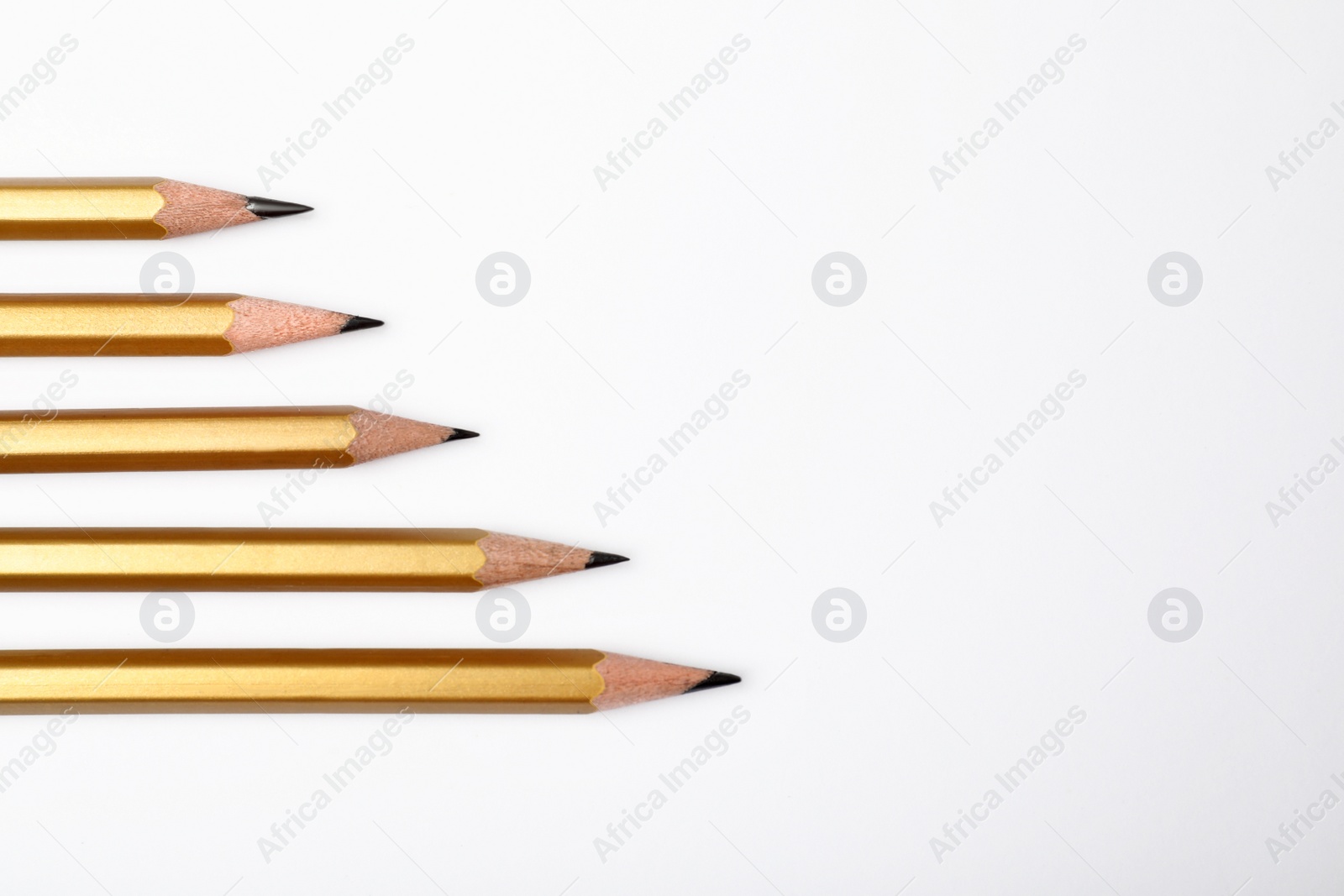 Photo of Pencils with longest one and space for text on white background, top view. Victory concept