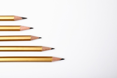 Photo of Pencils with longest one and space for text on white background, top view. Victory concept