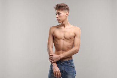 Photo of Shirtless man with slim body on grey background