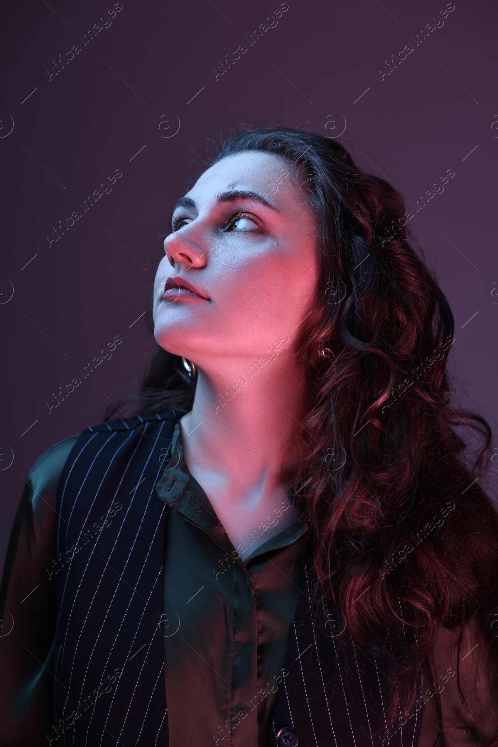 Photo of Portrait of beautiful young woman on color background with neon lights