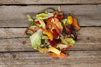 Photo of Peels of fresh vegetables on wooden table, top view