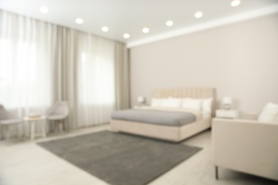 Photo of Blurred view of beautiful hotel room interior with double bed