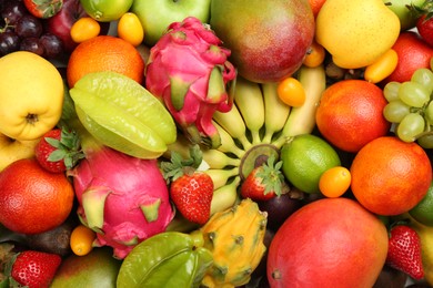 Photo of Assortment of fresh exotic fruits as background, top view