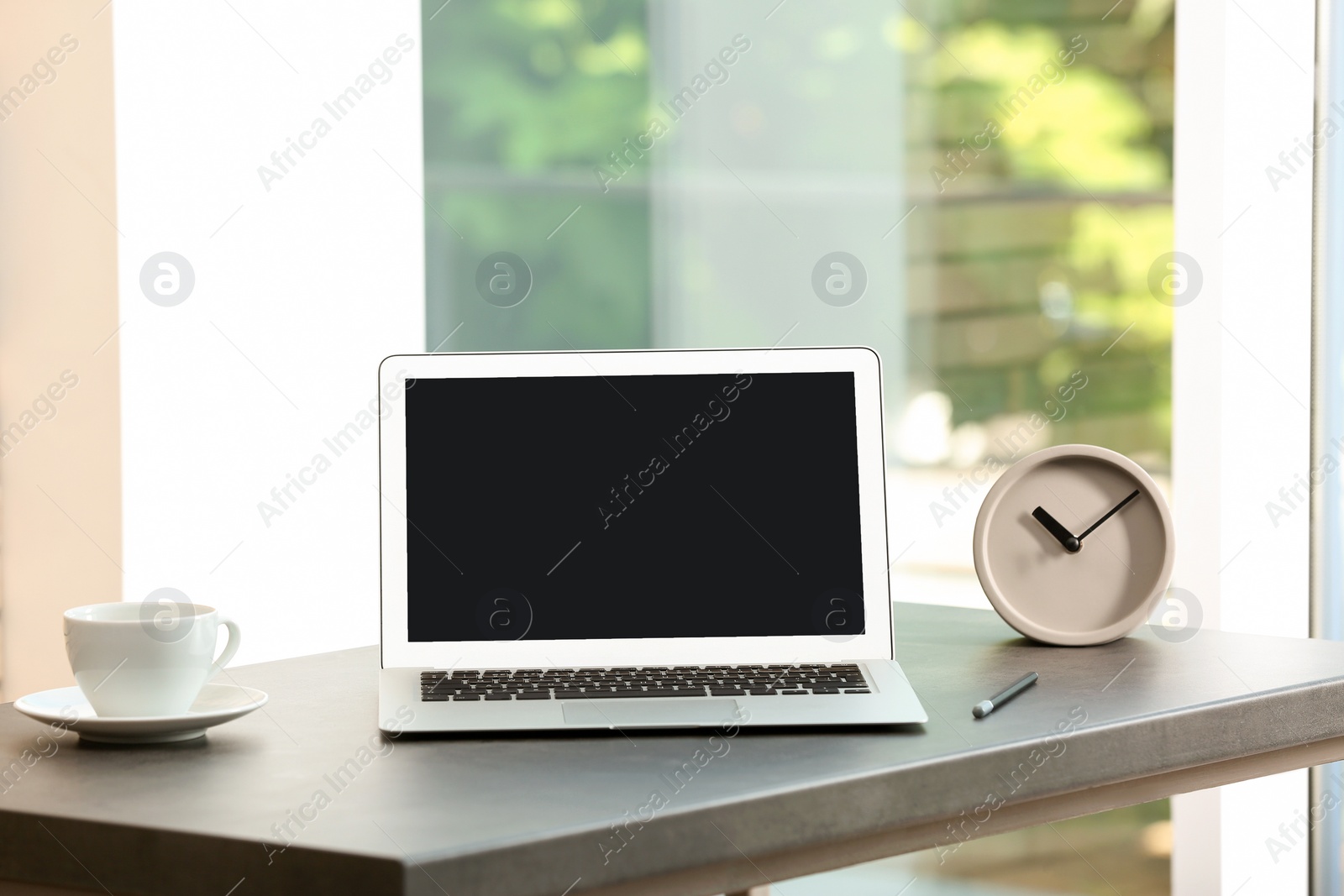 Photo of Modern laptop on table against window. Mock up with space for text