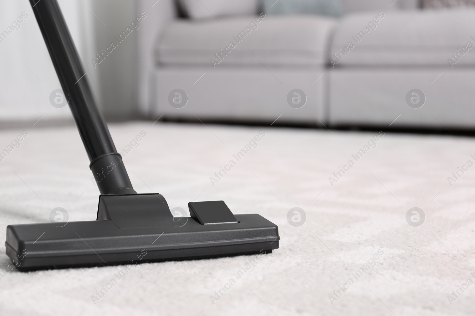 Photo of Hoovering floor with modern vacuum cleaner, closeup. Space for text