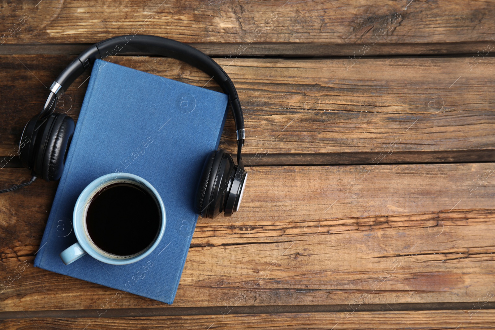 Photo of Book, coffee and headphones on wooden table, flat lay. Space for text