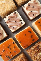 Pieces of different delicious cakes on grey table, flat lay