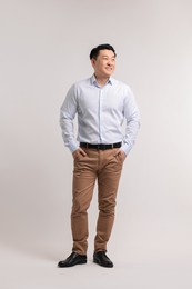 Full length portrait of happy man on light background