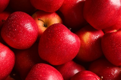 Fresh red apples with drops of water as background