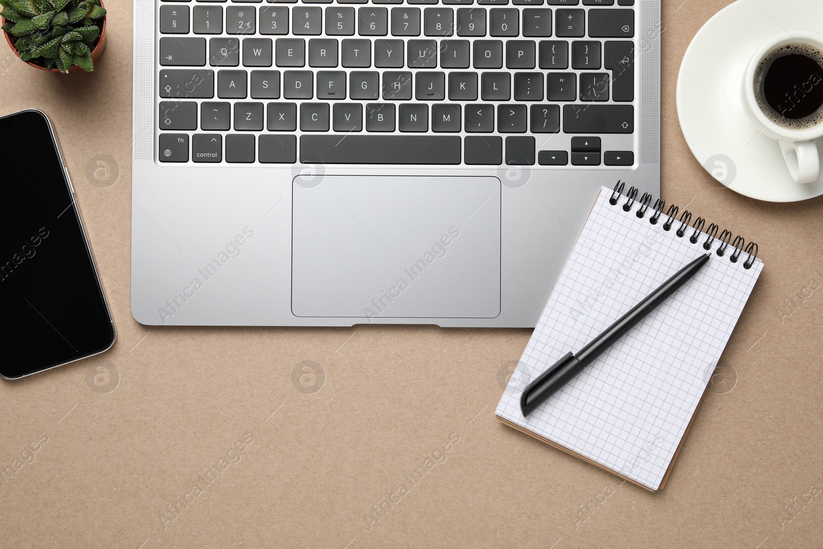 Photo of Modern laptop, notebook and cup of coffee on beige table, flat lay. Space for text