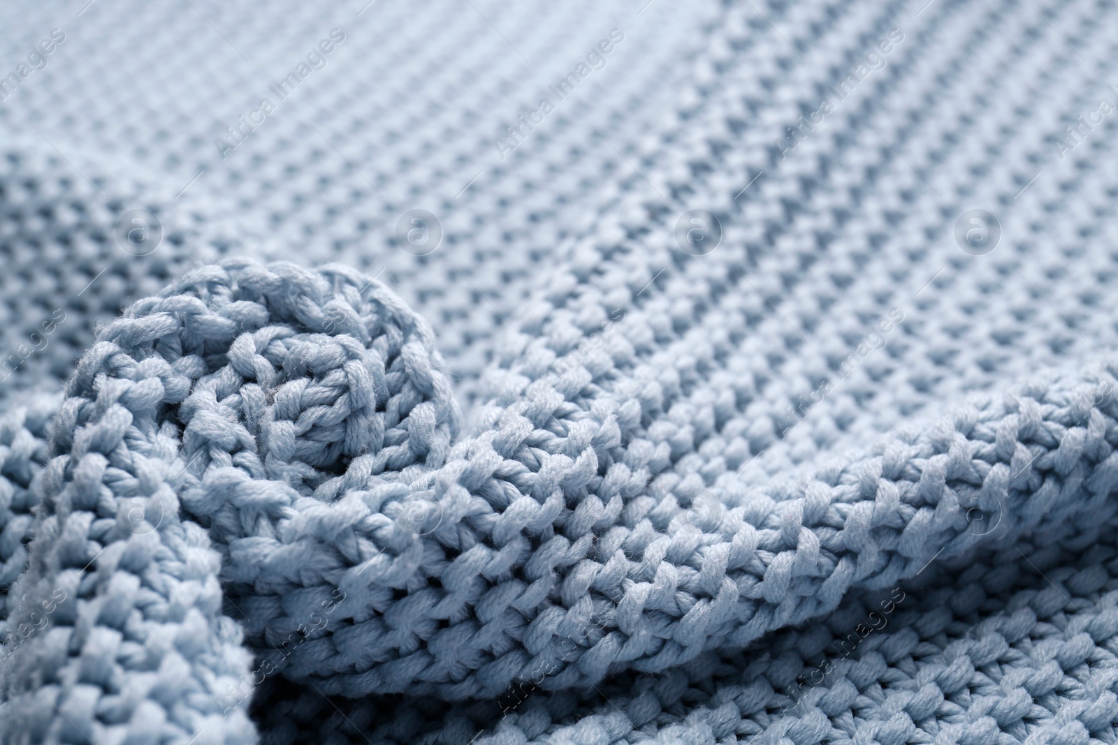 Photo of Beautiful light blue knitted fabric as background, closeup