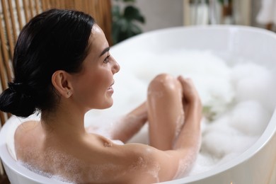 Photo of Beautiful young woman taking bubble bath at home