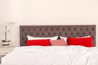 Photo of Double bed with bright pillows in room. Interior design element