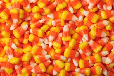 Photo of Delicious candy corns as background, top view