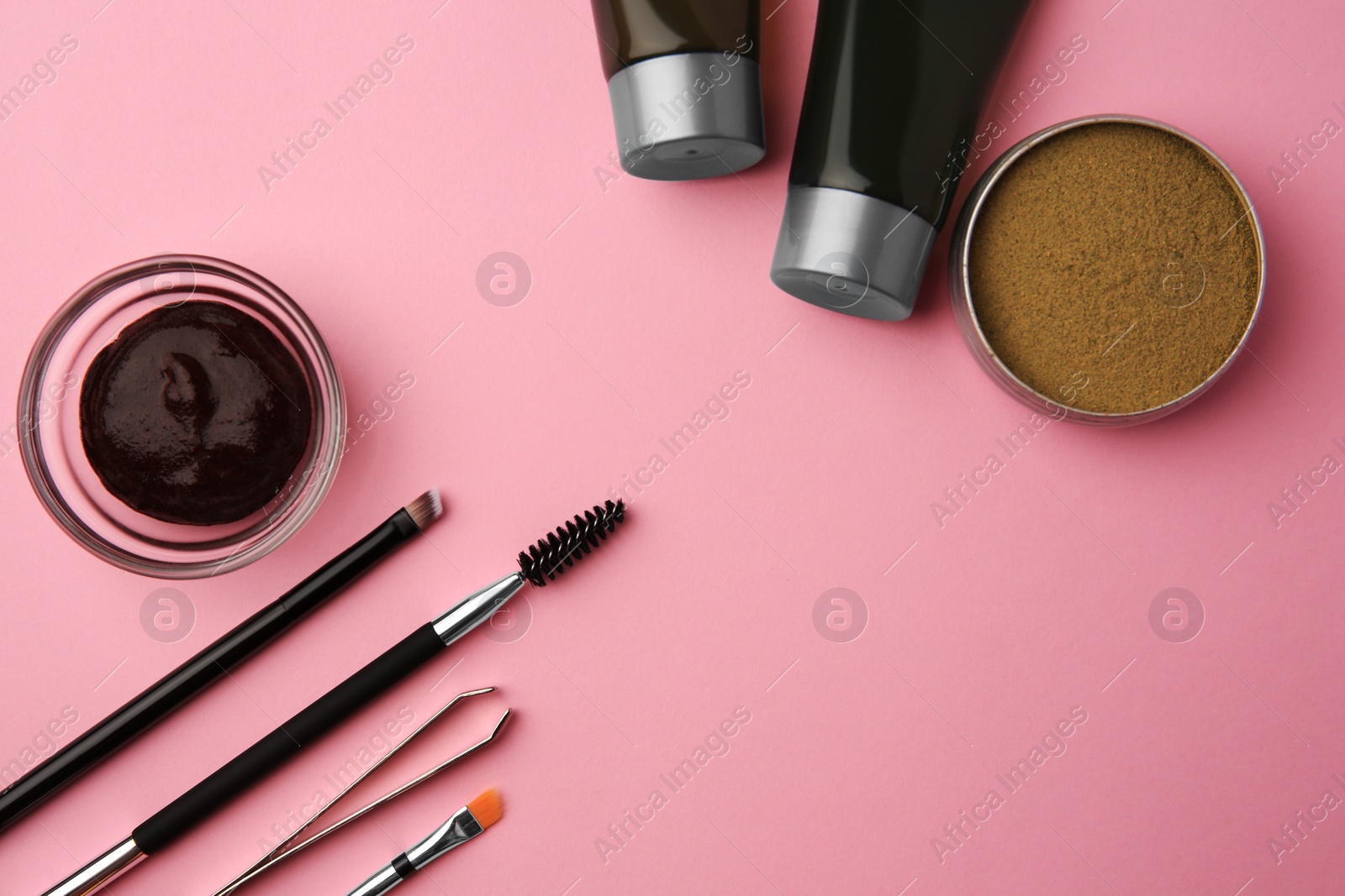 Photo of Flat lay composition with eyebrow henna and tools on pink background. Space for text