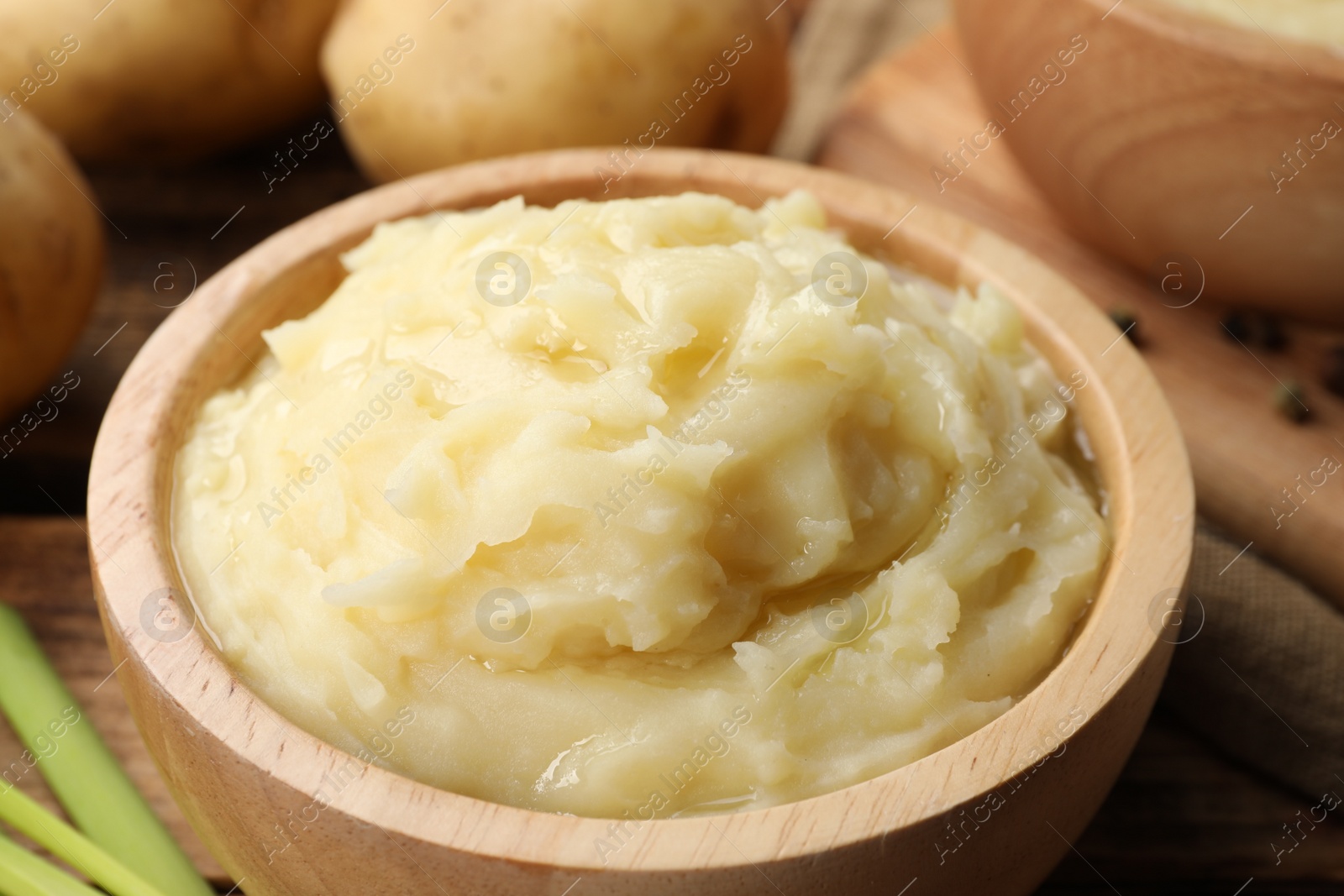 Photo of Bowls of tasty mashed potato on wooden table, closeup