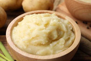 Bowls of tasty mashed potato on wooden table, closeup