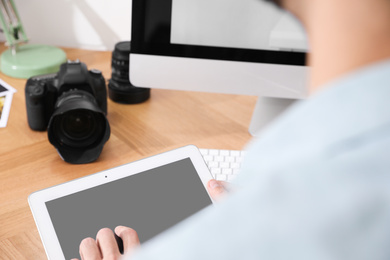 Photo of Professional photographer working at table in office, focus on hands
